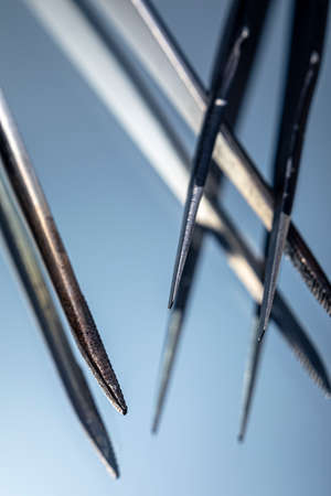 A closeup of two tweezers on a mirrored surface. Tweezers macro photo.の写真素材