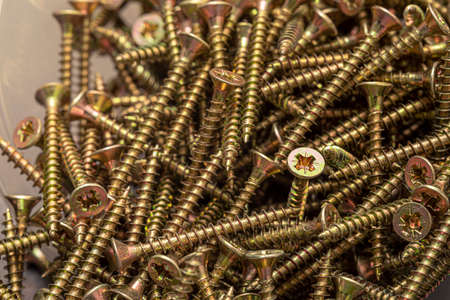 A handful of self-tapping screws made of steel. Construction abstraction. Industrial background.の写真素材