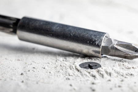 Black self-tapping screw screwed into a dowel installed in concreteの写真素材