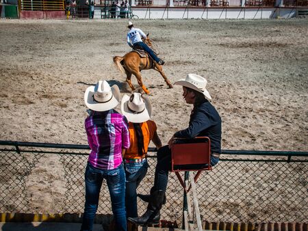 Cuban Young barrel riders rests after their competition and watches the Rodeo.