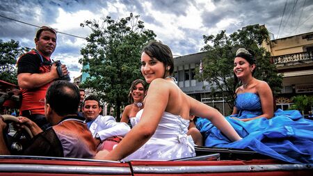 Sancti Spiritus, Cuba: Oct 10, 2013 A quinceanera and her girlfriends being driven around city downtown on October 10th 2013 in Sancti Spiritus, Cuba. Quinceanera is a traditional Cuban coming-of-age party for 15 year old girlsのeditorial素材