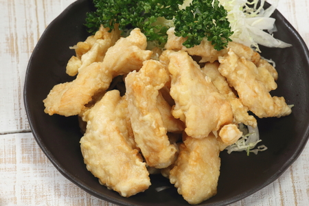 Deep-fried soft chicken on black plateの写真素材