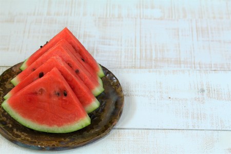 Watermelon slice arranged on a white wooden boardの写真素材