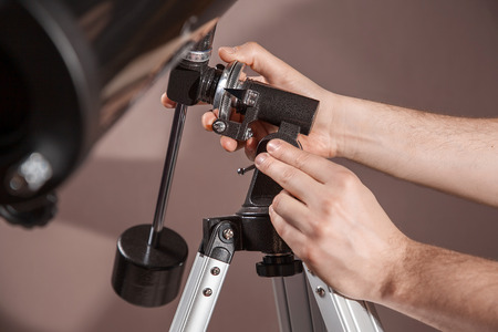 man adjusts a telescope closeup.の写真素材