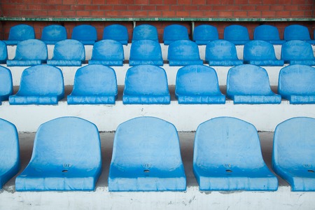 row of empty blue plastic chairs at stadium.の写真素材