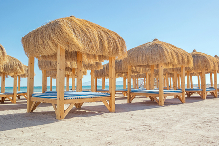 beach with thatched gazebo and sun loungers.の写真素材