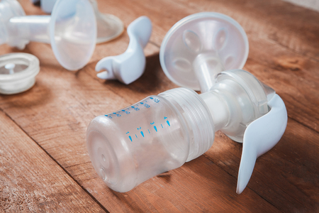 manual breast pump and parts on wooden tableの写真素材