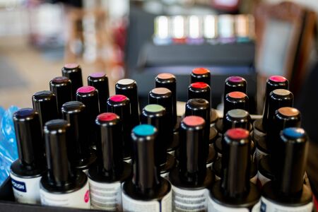Collection of colourful nail varnish lids in box with bokeh backgroundの写真素材