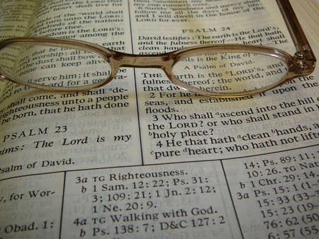 Study Bible with eye glasses on top.の写真素材