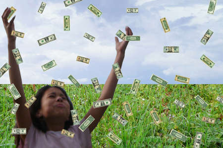 Child collecting money as it falls.の写真素材
