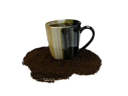 Cup of coffee surrounded by ground coffeeの写真素材