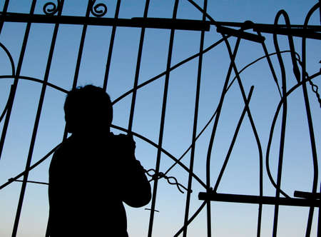 silhouette of a boy near the fenceの写真素材