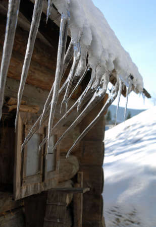 Old wooden hut with iciclesの写真素材