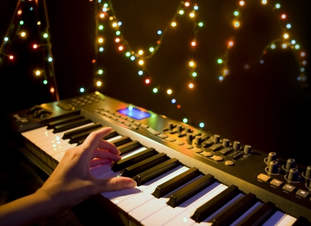 Musician playing on musical keyboard  Close up of a hand playing a MIDI controller keyboard in black background の写真素材