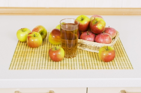 Apple juice in a glass on a table with apples の写真素材