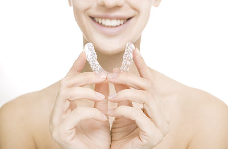 Beautiful smiling girl with tooth tray (hands holding individual tooth tray)の写真素材