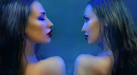 Fashion Beauty. Mystic Make-up. Two mysterious Beautiful Womans With Luxury glossy Makeup. Beautiful sensitive Girl Face. Constellation of the Twins (blue filter)の写真素材