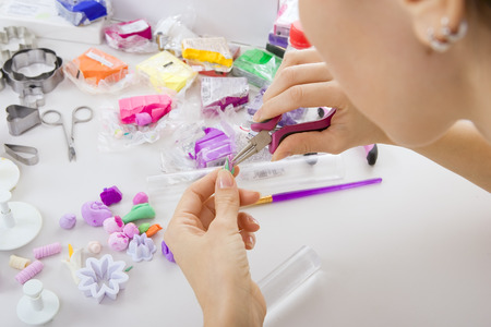 Artist makes jewelry from polymer clay, artist at work. Workshop