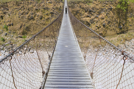 Pokhara city: Mountain river Landscape, Trek to Pokhara, Nepal.Long suspension foot Bridge with...