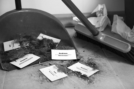 Staff reduction concept - Cutting staff and employee Job Reduction. Dismissal. Office cleaner throw in the debris staff business cards. Crisis management and HR policy. Job lossの写真素材