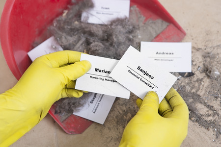 Staff reduction concept - Cutting staff and employee Job Reduction. Dismissal. Office cleaner throw in the debris staff business cards. Crisis management and HR policy. Financial Consultant hireの写真素材
