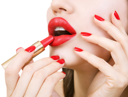 Sexy Young Beautiful brunette Girl with Red Nails holding red lipstick. Female Glamour portrait, sensual bright Make-up and Manicure closeup. Youth trendy fashion look. White backgroundの写真素材