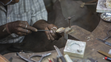 Indian Jeweler making an Oriental Jewelry in workshop. Handmade traditional jewel Manufacturing in Jaipur (Rajasthan). Jewelry Manufacturing Process in India. Indian Silver and Gold Jewel and Gemsの写真素材