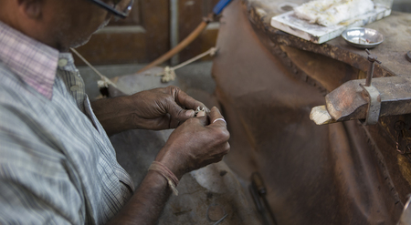 Indian Jeweler making an Oriental Jewelry in workshop. Handmade traditional jewel Manufacturing in Jaipur (Rajasthan). Jewelry Manufacturing Process in India. Indian Silver and Gold Jewel and Gemsの写真素材