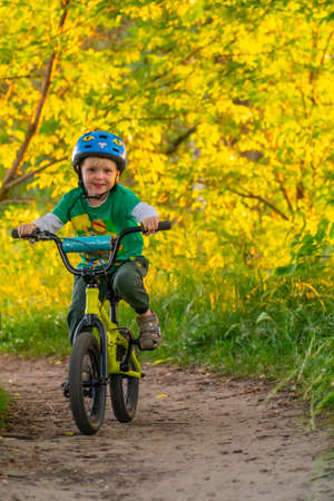 A child rides a bicycle on a summer sunny day and enjoys the rideの写真素材