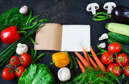 Fresh vegetables on a dark background, a notebook for recipes.の写真素材