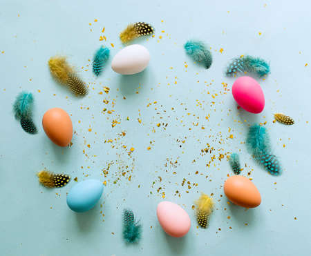 Easter background with colorful eggs on pastel blue background.
