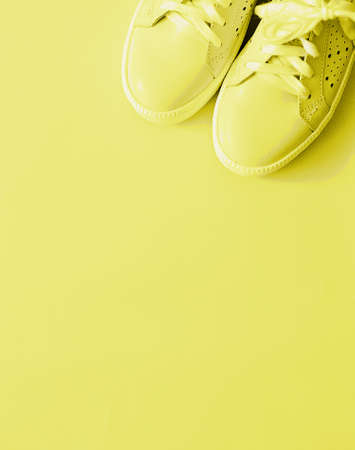 Sneakers on a yellow background, color of the year 2021. The concept of sports, fitness, workouts.の写真素材