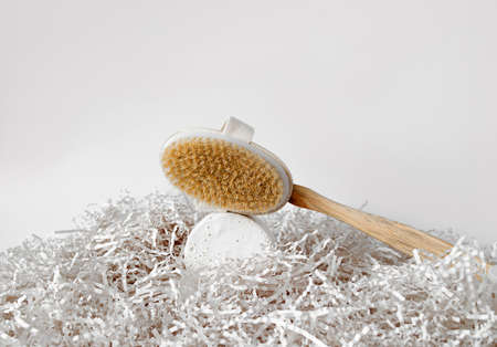 Wooden massage brush for dry, anti-cellulite massage on a concrete podium, with paper decor.の写真素材