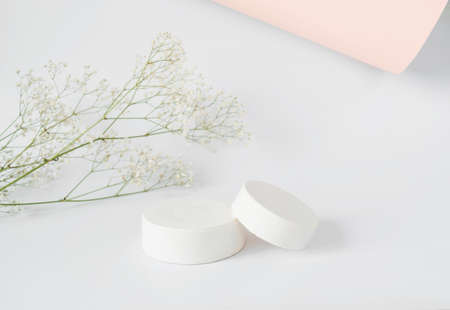 Mockup background for product presentation. Concrete podium and branch with flowers in the background on white.Front view.の写真素材