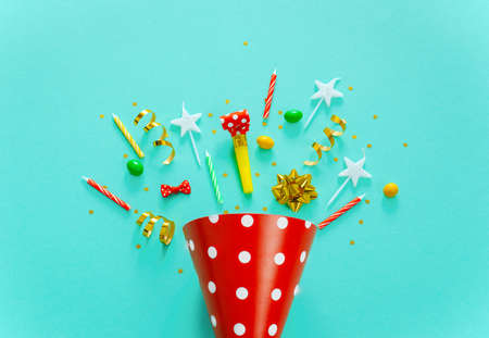Happy birthday background: party hat, serpentine, stars, cocktail tubes, candles, blower on a yellow background.の写真素材