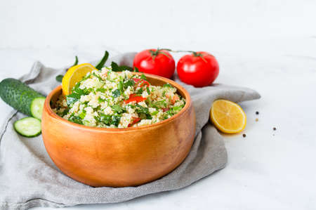 Traditional oriental salad Tabouleh with couscous or bulgur on a white marble background.の写真素材