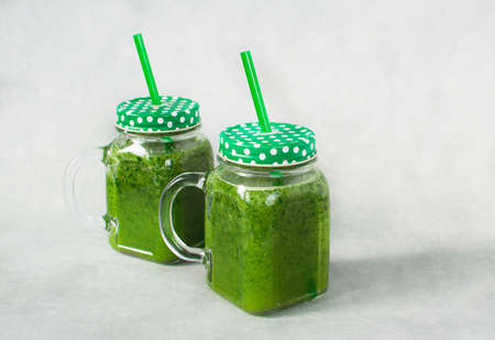 Green smoothie in glass jar made from spinach, celery, orange, apples. Detox concept, healthy food, diet, vegetarian Copy space.の写真素材