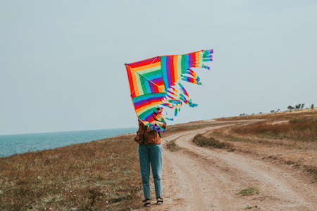 A young woman flies a kite on the seashore. The concept of freedom, travel, vacation.の写真素材
