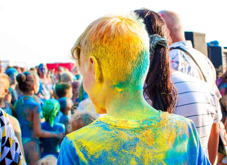 Young teenager at the festival of colors. Holi Indian Colors Festival. Digital detox, lifestyle, outdoor activities.の写真素材