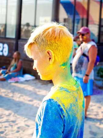 Young teenager at the festival of colors. Holi Indian Colors Festival. Digital detox, lifestyle, outdoor activities.の写真素材