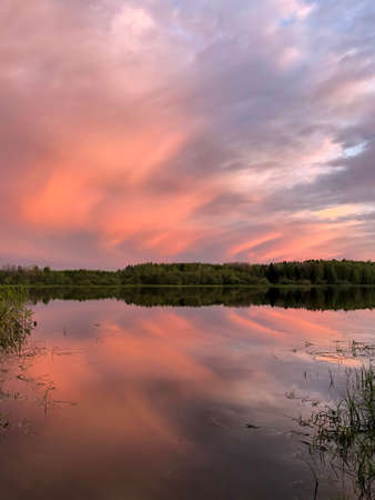 Dramatic sunset clouds over lake and trees - stock photoの写真素材