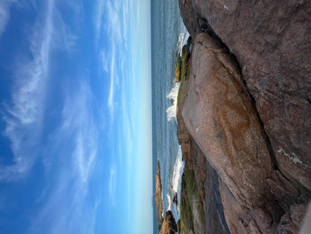 Rocky coast of the Atlantic Ocean with a blue sky and white cloudsの写真素材