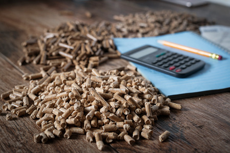 Calculating household heating costs. Wooden pellets, biomass, effective, environmentally friendly and economical heating, sustainable and renewable energyの写真素材