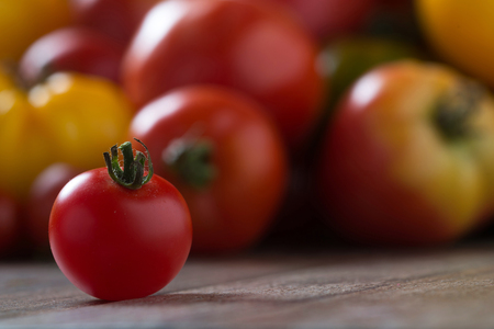Colorful tomatoes on rustic wooden background. Shallow depth of field.の写真素材