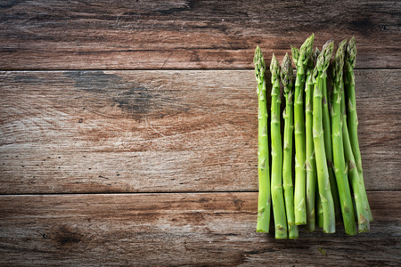 Bunch of fresh asparagus on wooden rustic background. Copy spaceの写真素材
