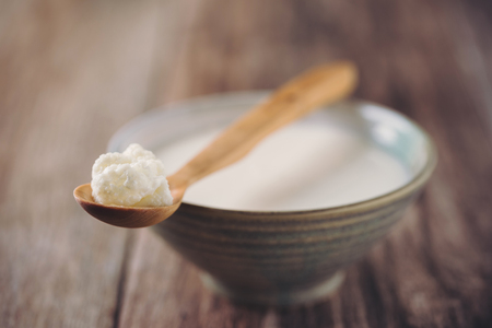 Kefir Grains on Wooden Spoon with a Cup of Kefir in background. Homemade Organic Probiotic. Shallow Depth of Field.の写真素材