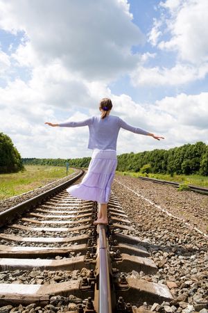 a walking girl on the railway under the blue sky の写真素材