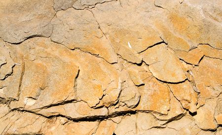 a strongly cracked yellow background of stone の写真素材