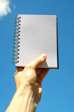 hand with blank white paper notebook isolatedの写真素材