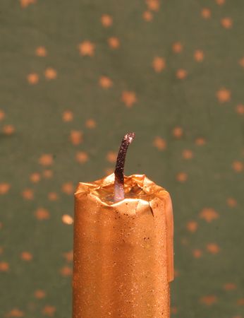 a golden candle on green backgroundの写真素材
